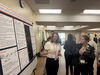 Undergraduate presents research poster to attendee of neuroscience conference