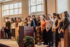 students stand on stage while being recognized for their academic achievements