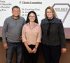 Lin-Feng Chen and Susan Martinis stand in front of projector screen with Phd student Xiaodan Lin