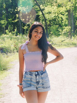 Julie Mathews smiles outside on a trail on a summer day.