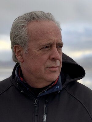 Man with white hair wearing black jacket